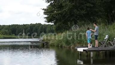 父子俩轻松地在淡水池塘钓鱼